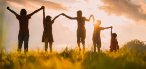 Five children joining hands in the sun